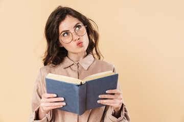 Image of thinking caucasian woman in eyeglasses reading book
