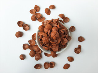 Cocoa crunch cereal or cornflakes, on a small plate. Isolated in white background.