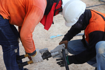 The electrician is connecting the high voltage cables together.