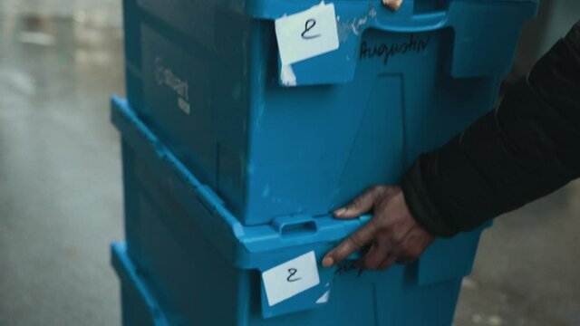 Close Up. The Hands Of An African-American Male Push Blue Boxes With Goods. Food Delivery, Street Courier