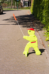 View on plastic figure on the street, standing there to warn cardrivers to drive slowly. Children might be playing and overlook cars. This sign is meant to improve caution and carefulness