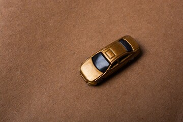Close up shot of a yellow taxi toy car in a brown background