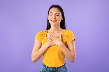 Happy woman posing and keeping hands on chest