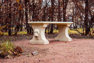 a stone bench with the lion bas relief in the park of Oranienbaum