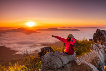 Young girl in red jacket hiking on the mountain, Doy-pha-tang, border  of  Thailand and Laos.