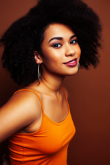 Fototapeta premium pretty young african american woman with curly hair posing cheerful gesturing on brown background, lifestyle people concept