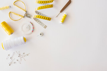Measuring tape, scissors and threads, tools for sewing, flat lay frame on a white background. Copy space