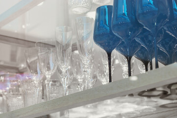 Many transparent wine glasses on a thin high leg in the window of a large cookware store.