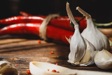 Poster Garlic and chili pepper on dark wooden table © fotofabrika