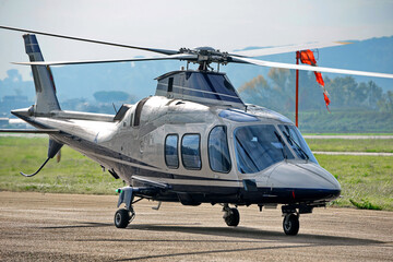 Helicopter ready on runway under cloudy sky
