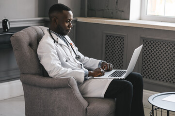 portrait of afro american doctor using laptop computer. online consultation