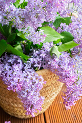 Fototapeta premium blooming lilac in a wicker basket near the window close up