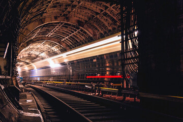 A passing train the lights of the metro tunnel.At the intersection of two metro lines.Goes into the...