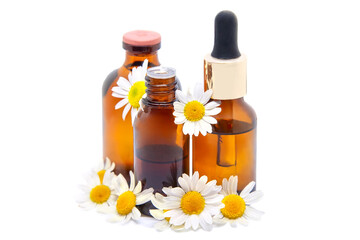 Essential chamomile oil, tincture,extract in glass bottles with fresh camomile flowers