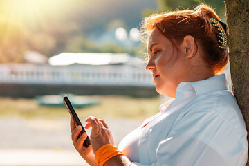 Communication. Portrait of a woman using a cellphone. The concept of online addiction and social network. Outdoor