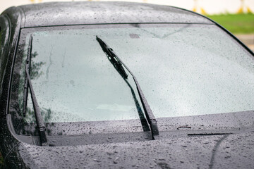 Black Saloon parked in the rain on the side of the road