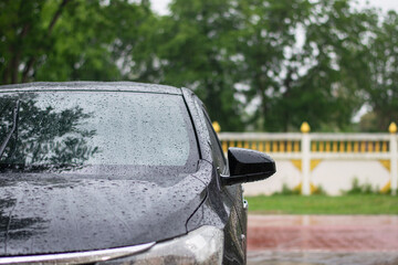 Black Saloon parked in the rain on the side of the road