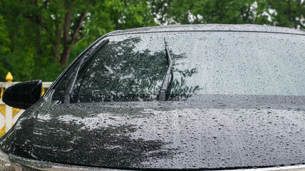 Black Saloon parked in the rain on the side of the road