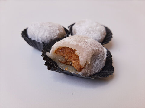 Moaci or Mochi covered in white flour, in Indonesian version. Rice cake filled with sweet peanut paste. Isolated in white background