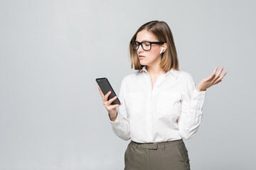 Fototapeta premium Young beautiful business woman talking via airpods wirrless headset holding phone isolated on white background