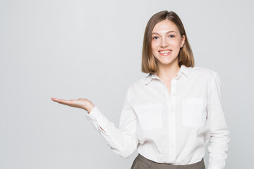 Businesswoman showing copy space for product with open hand palm. Smiling friendly expression on...
