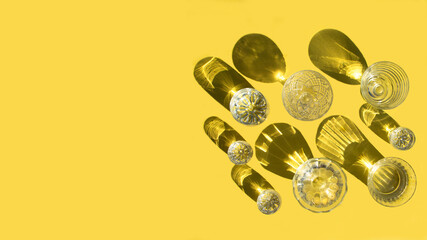 Glasses with clear water stand on a yellow background, top view. Beautiful creative still life is...