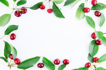 Frame of ripe cherries with leaves. Summer background. Ripe sweet cherries isolated on a white background. Copy space
