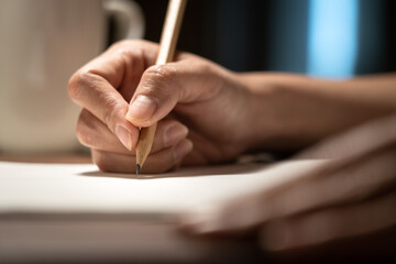 Handwriting on paper, people is using pencil to make at note on paperwork. Education/business...