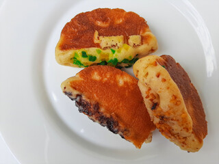 Pukis, is an Indonesian traditional pancake, with various toppings. On white plate. Isolated in white background.