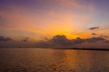 Burning bright sky during sunset on a tropical beach. Sunset during the exodus, the strength of people walking on water