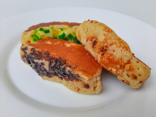 Pukis, is an Indonesian traditional pancake, with various toppings. On white plate. Isolated in white background.