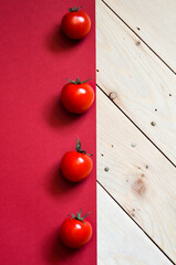 Naklejka na ściany i meble Tomato on wooden and red background. Fresh whole organic red tomatos, vegetable. Flat lay. Food concept. horizontal.