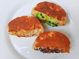 Pukis, is an Indonesian traditional pancake, with various toppings. On white plate. Isolated in white background.