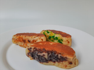 Pukis, is an Indonesian traditional pancake, with various toppings. On white plate. Isolated in white background.