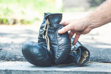 man hands holding a pair of boxing gloves on the nature background