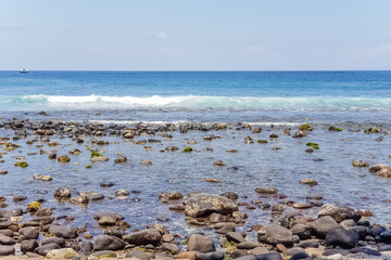 Fototapeta na wymiar View on Indian ocean coast with pebble and sand beach on Bali, Indonesia