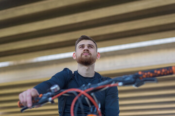 Closeup portrait of a bearded cyclist athlete guy. Outdoors. Spring sports. The guy is twenty-five years old. Cycling Spring bike ride. Extreme cycling. Active lifestyle