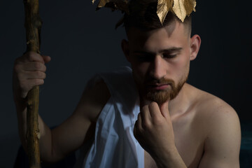Portrait of the ancient Greek god Olympus, in white clothes, with a wreath on his head, holds a...