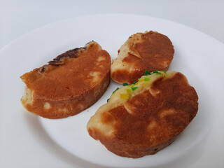 Pukis, is an Indonesian traditional pancake, with various toppings. On white plate. Isolated in white background.