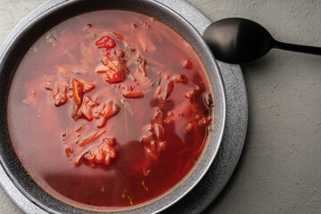 Traditional borscht in a gray tureen on a gray concrete surface top view, close-up