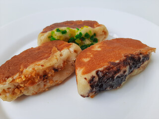 Pukis, is an Indonesian traditional pancake, with various toppings. On white plate. Isolated in white background.