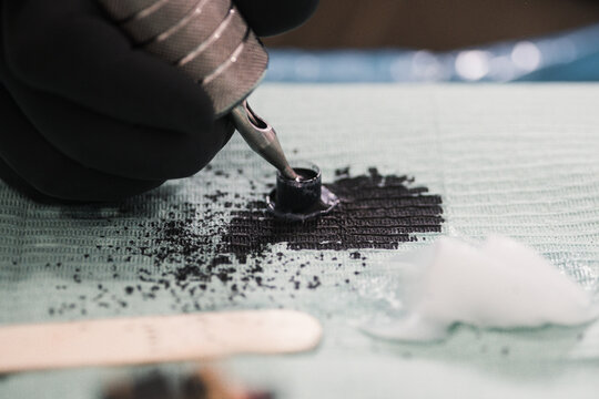 Aguja de maquina de tatuar cogiendo tinta negra 