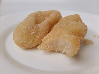 Getas, is a traditional cake from Indonesia. Made from grated coconut and rice flour, then fried and dipped into sugar. Isolated in white background. Top view or flat lay