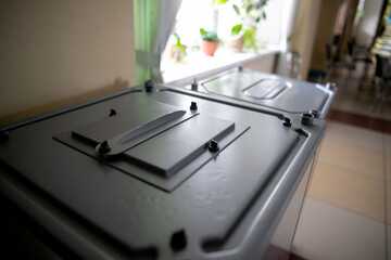 Ballot boxes for elections with the emblem of Russia at a polling station.