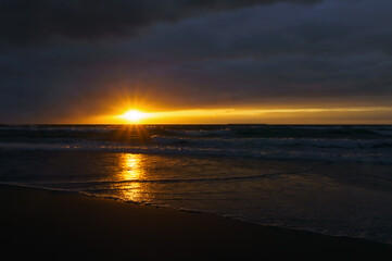 Waves and wind at sunset. Stormy sea at sunset.