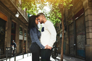 Fototapeta premium Good-looking woman and her attractive boyfriend stand very close to each other. The guy lovingly looks at his mate and holding her hand. She closed her eyes and dreaming about something pleasant.