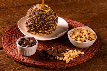 Candied apples on sticks with caramel, chocolate and peanuts.