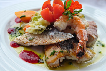 Delicious fish dish from traditional cuisine of Madeira island - grilled fillets of ocean codfish served with shrimps, shells, mussels and celery puree