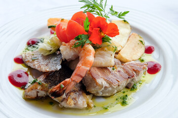 Delicious fish dish from traditional cuisine of Madeira island - grilled fillets of ocean codfish served with shrimps, shells, mussels and celery puree