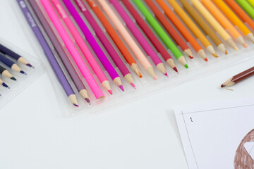 Colored pencils on a white background, close-up photo.